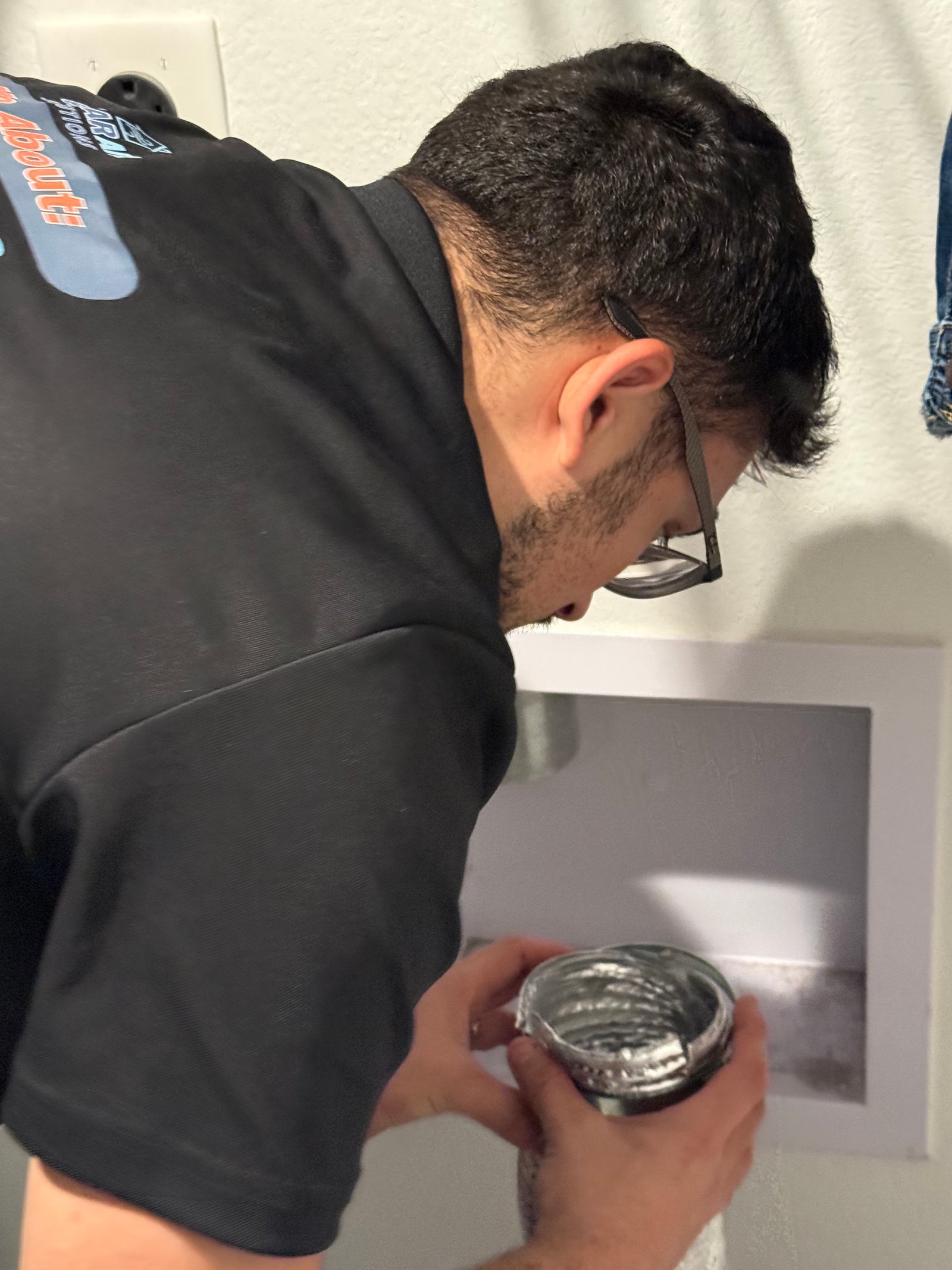 Technician inspecting dryer vent connection in Cypress