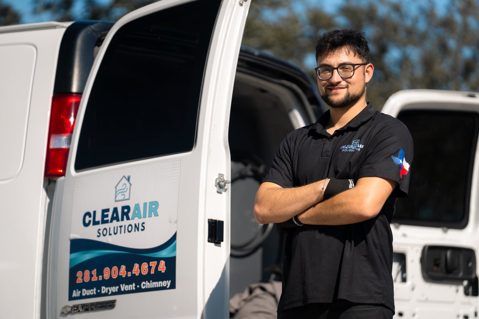 Adam from ClearAir Solutions standing by branded service van