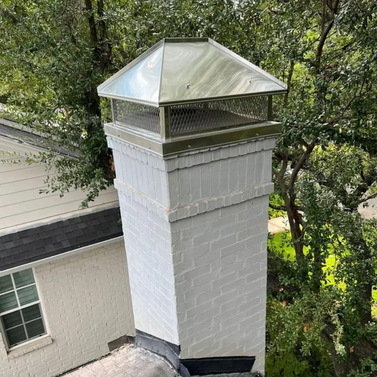 Stainless chimney cap on a freshly painted brick chimney